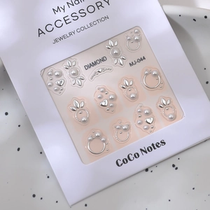 Détail d'autocollants 3D pour ongles avec cœurs argentés et perles dans l'emballage MJ-044