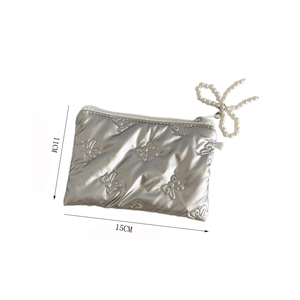 Detail view of silver embossed bow pouch with pearl zipper and 15cm size markers