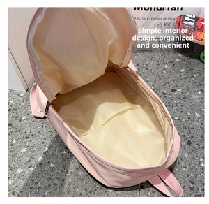 Vista interna dello zaino rosa con ampio scomparto principale e fodera color crema