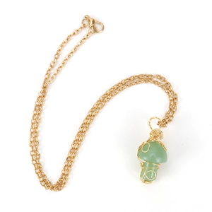 Macro shot of gold wire-wrapped green crystal mushroom pendant on a delicate chain