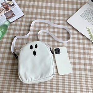 Sac à bandoulière fantôme blanc sur tissu à carreaux avec accessoires lifestyle