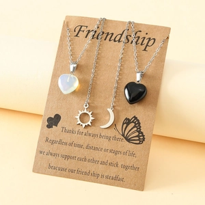 Friendship 4-piece necklace set with sun, moon, and heart charms on kraft card