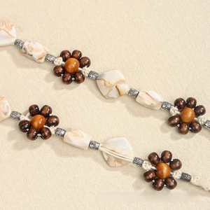 Macro detail of Bohemian woven belt showing wooden beads and marble resin textures