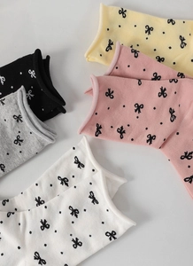 Flat lay of colorful cotton socks in black, grey, white, pink and yellow with bow patterns