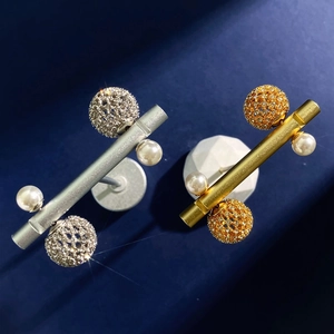 Elegant gold and silver pearl earrings with hollow pave diamond spheres on blue velvet