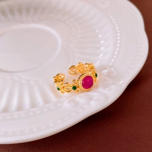 Détail d'une bague vintage plaquée or avec pierre rouge centrale et accents de zircon