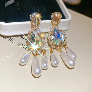 Detail of vintage gold-plated teardrop earrings with crystals and pearl tassels