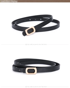 Detail of slim black PU leather belt with an oval gold metal pin buckle for women