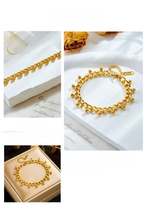 Detailed macro view of gold plated stainless steel chain bracelet with metal beads charms