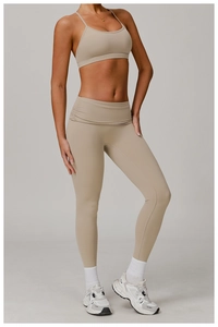 Detail view of high-waist yoga pants with ruched side waist design in beige