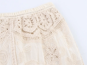 Vista macro detallada de la cintura de ganchillo boho y encaje en la falda beige