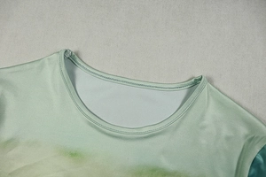 Macro detail of round neckline with green gradient pattern and durable stitching