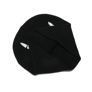Detailed view of black knitted beanie featuring white wing-shaped jacquard pattern