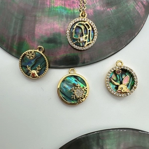 Detail of 18K gold-plated abalone shell pendants in snowflake, deer, and rabbit shapes