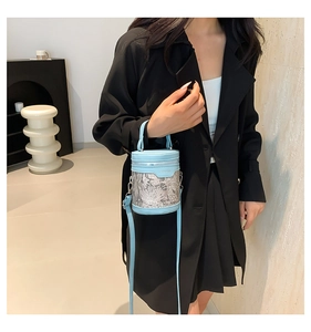 Blue lace embroidery bucket bag shown with adjustable shoulder strap on a model