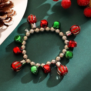 Detail of Christmas bracelet with red and green bells on dark festive background