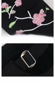 Detailed embroidery of pink plum blossoms and adjustable metal buckle on black baseball cap