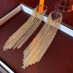 Detailed view of elegant gold metal tassel earrings displayed in a luxury jewelry box