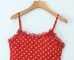 Detail des roten Polka-Dot-Kleides mit Rüschenausschnitt und feinen Spaghettiträgern