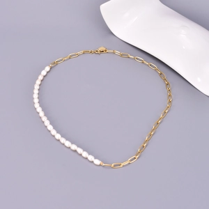 Detail of freshwater pearls and gold-plated paperclip chain necklace on gray background