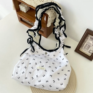 Detail van de lila tote bag met strik, geplooide schouderband en magneetsluiting