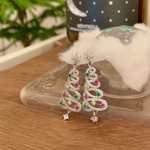 Macro shot of silver Christmas tree earrings with colorful rhinestones and star detail