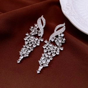 Detail of silver long tassel bow earrings with sparkling cubic zirconia on silk