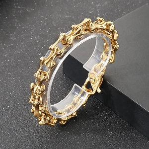 Detailed view of punk style gold bone link bracelet on a sleek display stand