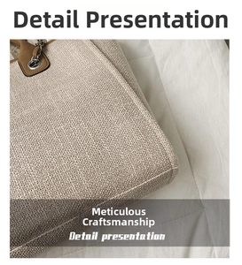Close-up of beige canvas tote bag showing fine stitching and metal chain handle detail