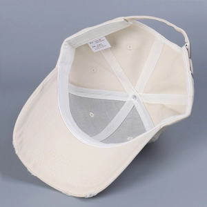 Detail of 100% cotton baseball cap interior showing adjustable metal buckle and wash label