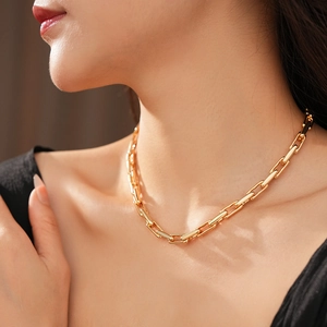 Close-up of golden paperclip chain necklace on neck with minimalist adjustable pendant