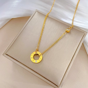 Detail of gold double-layer chain necklace featuring LOVE engraved round pendant with zircon