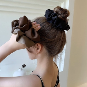 Elegant satin oversized scrunchies in black and brown on a bun hairstyle for women