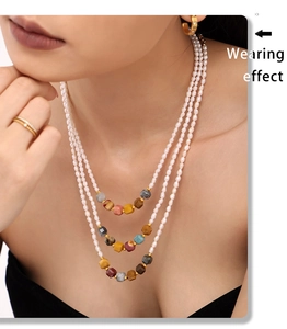 Close-up of layered necklace with freshwater pearls and colorful gemstones on a model