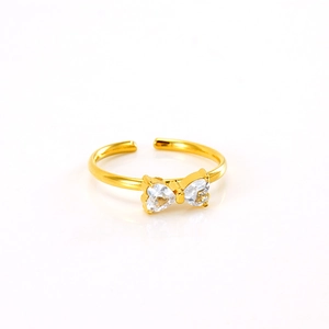 Detail of gold bow ring with heart-shaped zircon stones and adjustable open band design