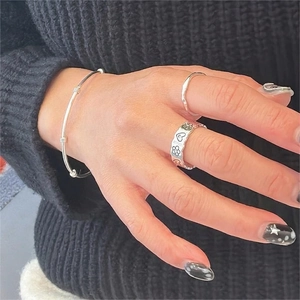 925 Sterling silver heart and flower engraved ring with twisted bangle on a hand