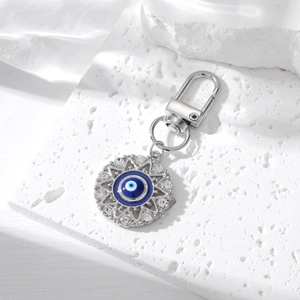 Detail of silver evil eye keychain with blue enamel inlay and sparkling rhinestones
