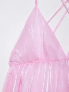 Detail van roze metallic halterjurk met gekruiste bandjes en glanzende textuurstof