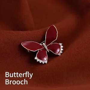 Elegant gold butterfly brooch with deep red enamel wings and sparkling zircon accents