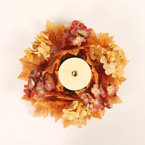 Fall candle ring with artificial maple leaves and orange hydrangeas on white background