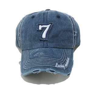 Close-up of distressed navy blue denim baseball cap featuring Lucky Number 7 embroidery