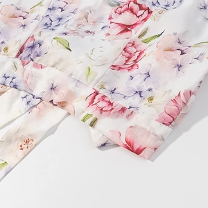 Détail de l'imprimé floral rose et violet sur mousseline blanche avec ourlet noué