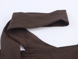 Vue macro détaillée de la texture du lin marron foncé et des finitions de couture