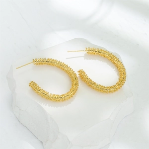 Textured 14K gold plated earrings for women displayed on a decorative stone base