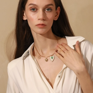 Close-up of 18K gold plated stainless steel heart and butterfly pendant necklace on model