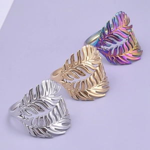 Detailed view of hollow leaf rings in silver, gold, and rainbow finishes on purple background