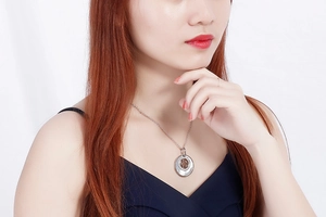 Detailed view of silver necklace with bear silhouette on mother of pearl pendant