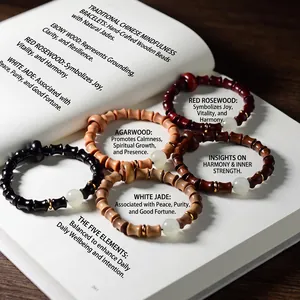 Bracelets en bois de santal lumineux avec joints en bambou et accents dorés sur un livre