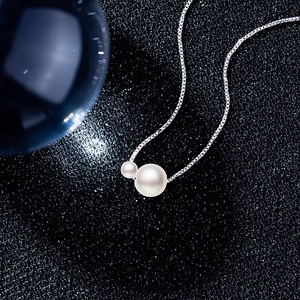 Elegant silver pearl necklace with two white beads on a dark starry background