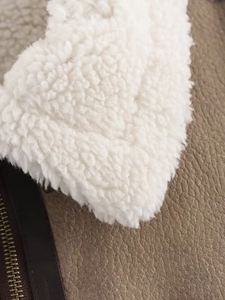 Detailed macro view of vintage brown faux leather jacket with warm sherpa lining texture